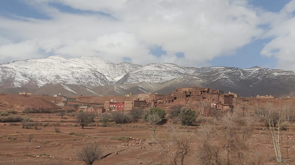 viajar a marruecos en enero y febrero pueblo del atlas con montañas nevadas al fondo