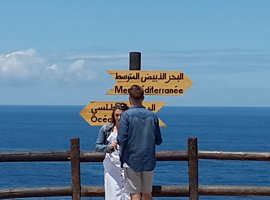 pareja delante cartel cruce de mar Mediterraneo y Atlántico en Cap Spartel Tánger